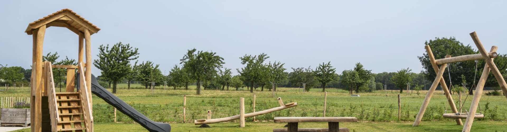 Omheinde tuin met speeltoestellen
